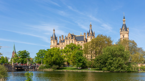 Schwerin Castle on Island in Schwerin Mecklenburg Vorpommern land Germany. Scenic view of historic german Schweriner palace with green garden against bright blue sky in Europe travel destination